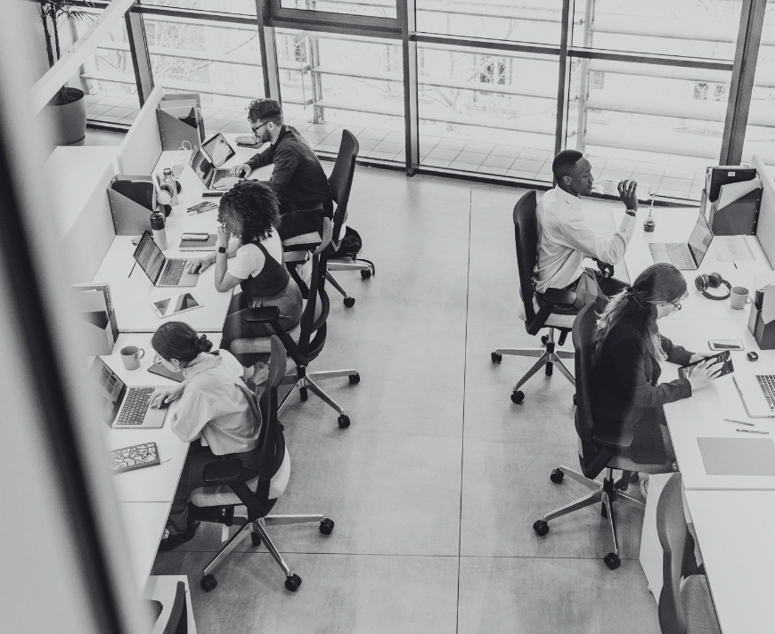 A business team is gathered around a table, analyzing SharePoint storage reports and governance policies, focusing on site collection administration and storage metrics. They are discussing current storage limits, site settings, and the need for additional storage space for their SharePoint sites.